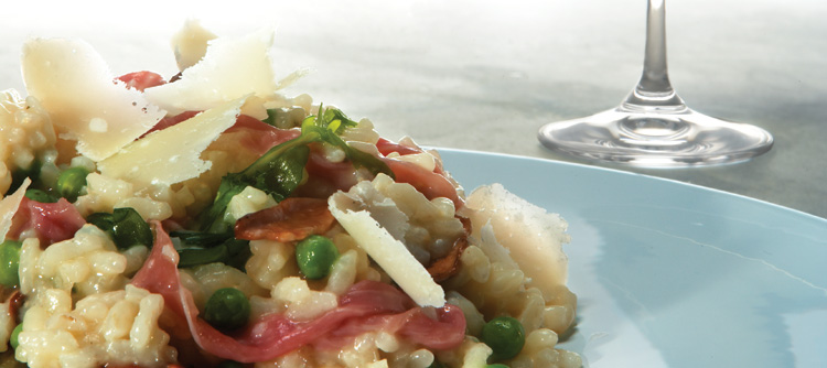 Parma Ham risotto with porcini mushrooms, peas and rocket, scattered with Parmigiano-Reggiano cheese shavings