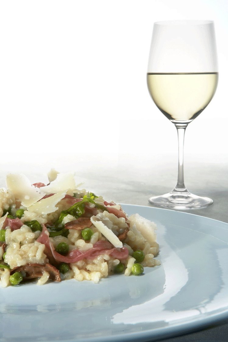 Parma Ham risotto with porcini mushrooms, peas and rocket, scattered with Parmigiano-Reggiano cheese shavings